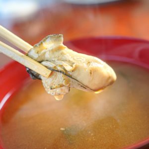 牡蠣の味噌汁から牡蠣の身を箸でつかむ